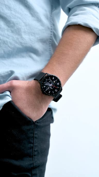 The ZIZO Tyme Elite 2 smart watch in black worn on a wrist, a rolled light-blue sleeve above it