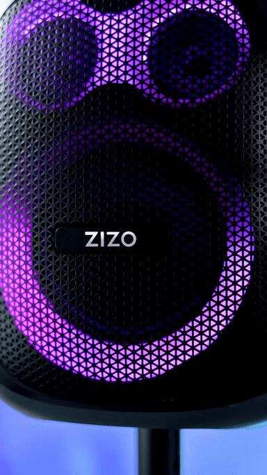 The ZIZO Tune Z5 party speaker's honeycomb grille lit magenta, two driver rings glowing around the centered ZIZO badge