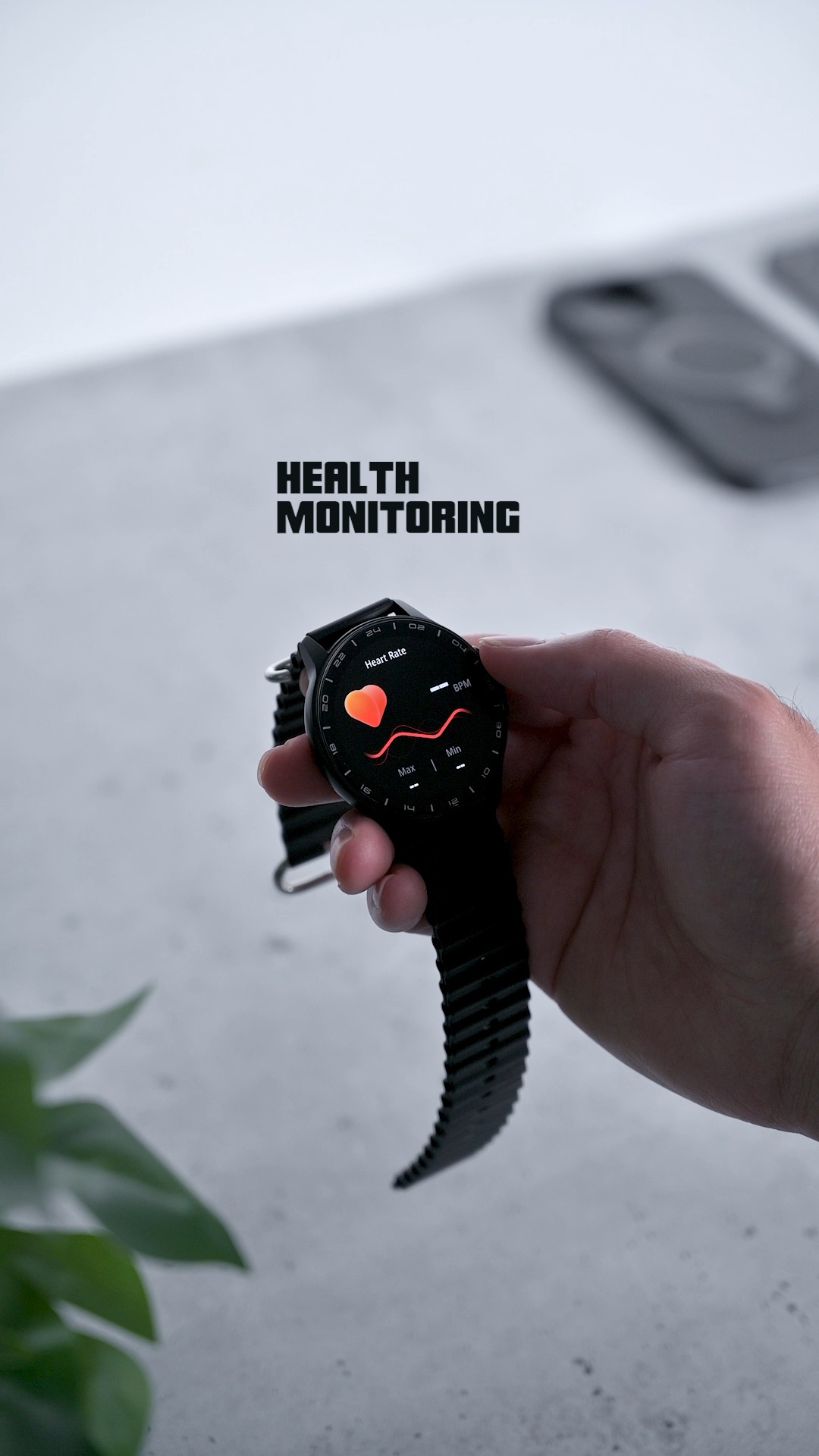 The ZIZO Tyme Elite 2 held in a hand, its screen showing a heart-rate reading