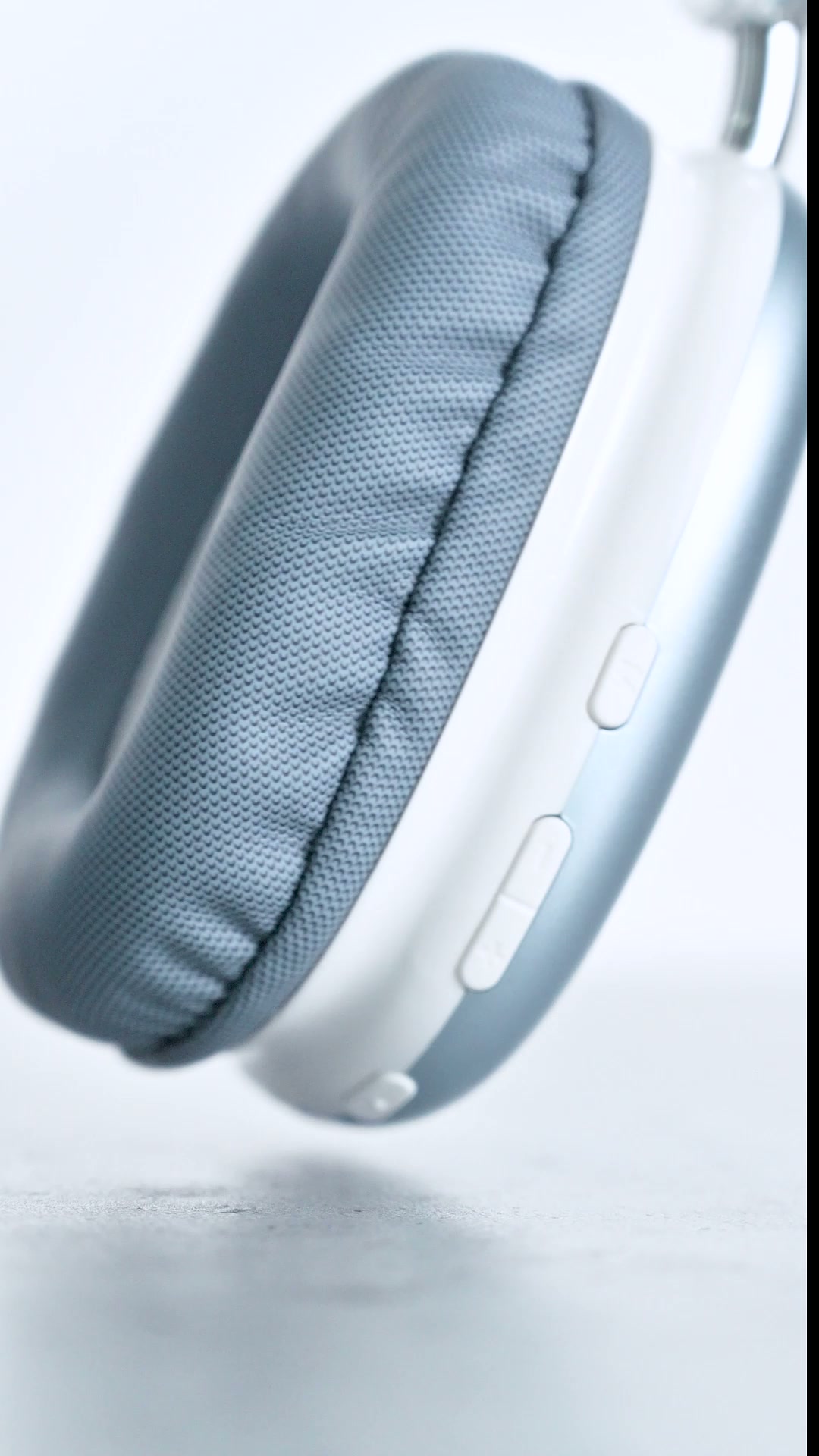 A close view of the rim of a pale ZIZO Tempo Pro earcup, showing two buttons set into the edge beside the cushion