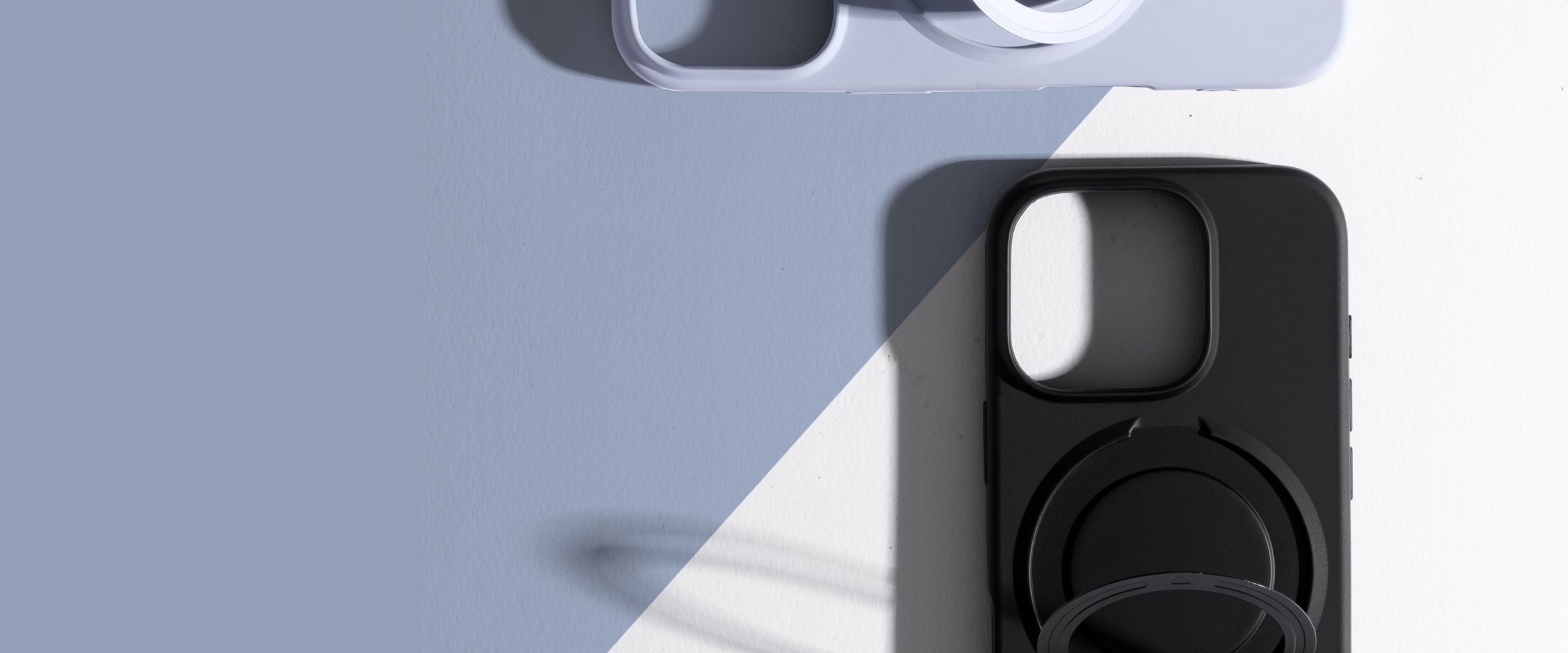 Two ZIZO Revolve cases, one black and one pale lavender, on a sunlit surface cut by a sharp diagonal shadow