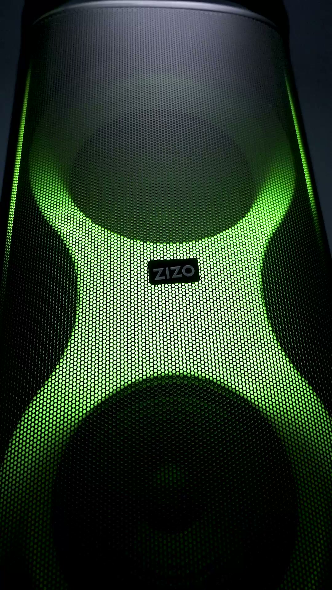 Close view of the ZIZO Boom speaker grille lit green, with the ZIZO badge on the mesh